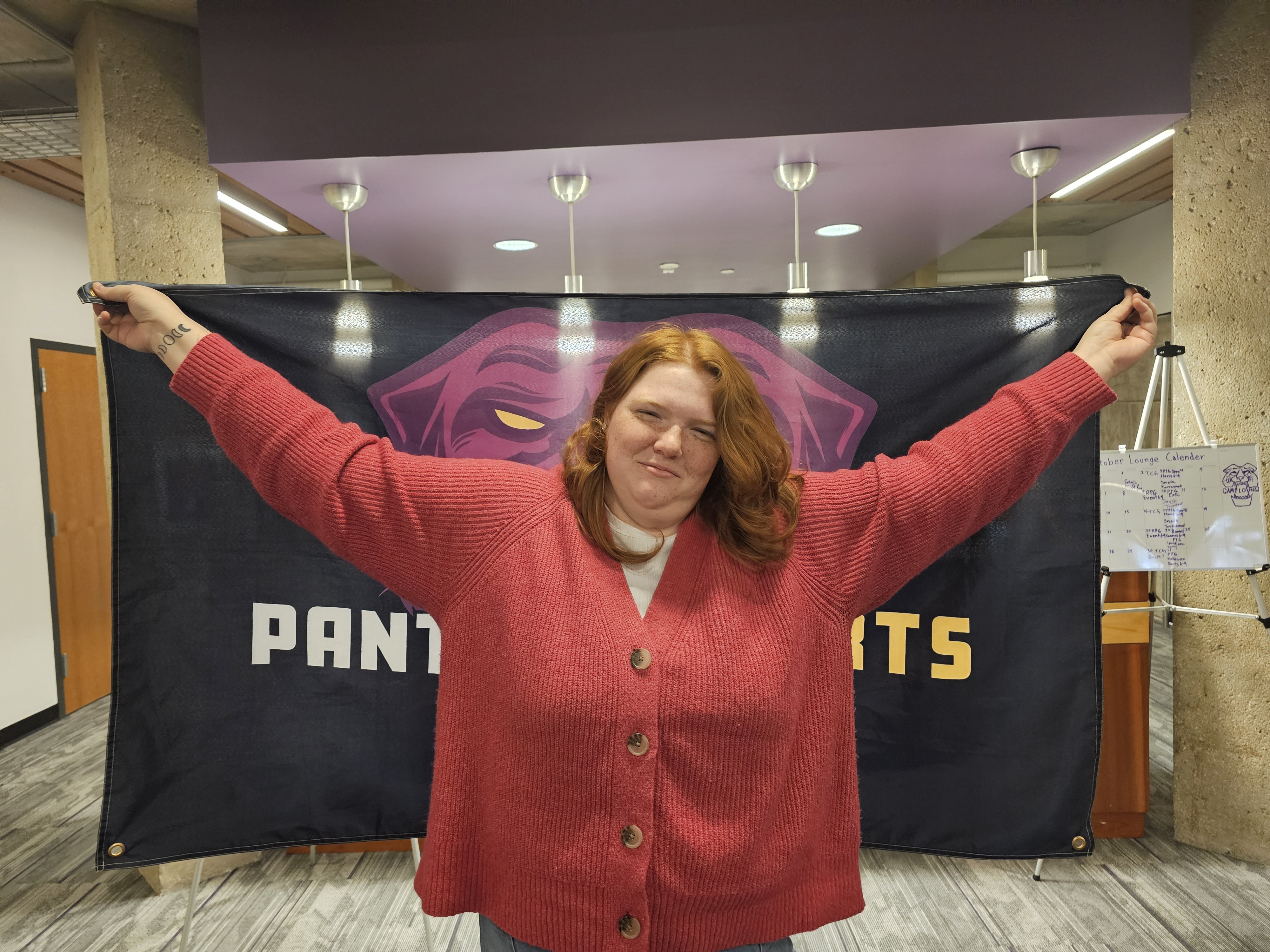 Peyton holding a Panther Esports flag behind her.