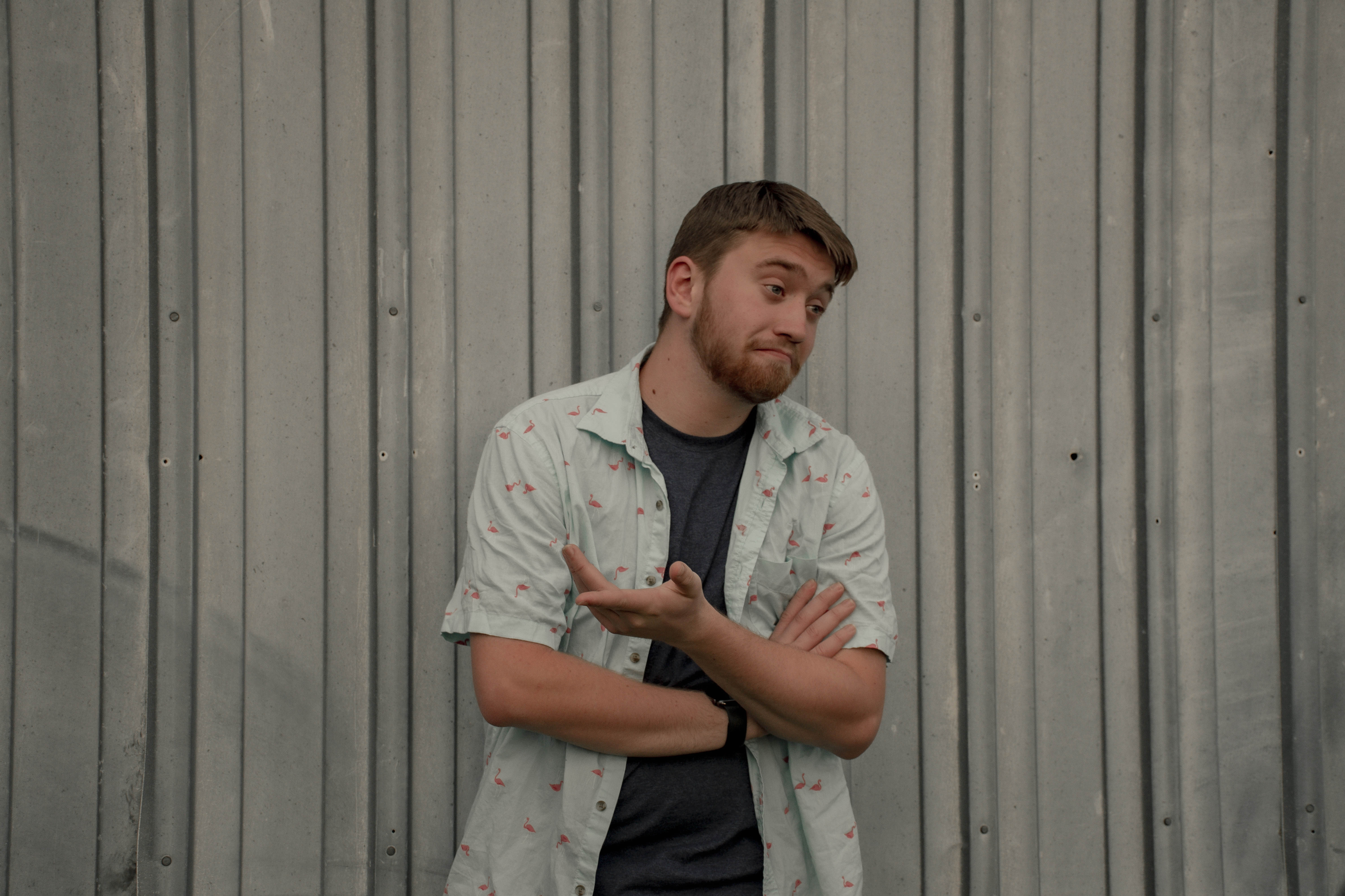 Daniel shrugging in a button up shirt. 